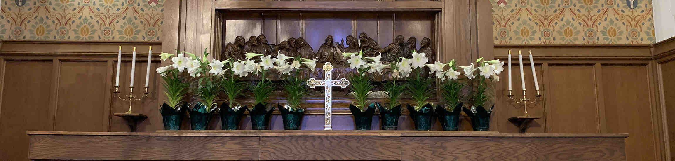 Gold cross surrounded by easter lilies
